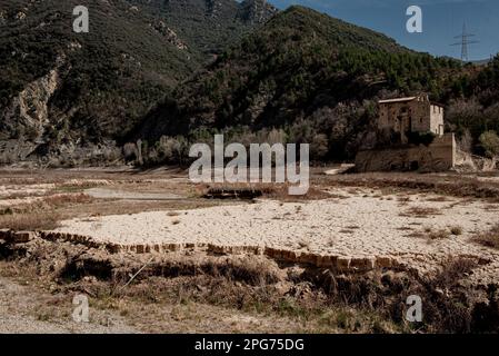 L'antico monastero romanico di Sant Salvador de la Vedella, che normalmente è circondato dall'acqua, è visto sul letto secco del fiume Llobregat mentre entra nel bacino idrico di la Baells a Cercs, nella provincia di Barcellona, in Spagna. Le restrizioni idriche sono state ulteriormente rafforzate in Catalogna a causa della siccità in corso, che è ormai da 29 mesi e che è legata al cambiamento climatico e al riscaldamento globale. Attualmente, i serbatoi catalani sono al 27 per cento della loro capacità. Foto Stock