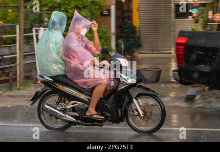 SAMUT PRAKAN, THAILANDIA, 21 2022 SETTEMBRE, coppia in impermeabile guidare sotto la pioggia Foto Stock