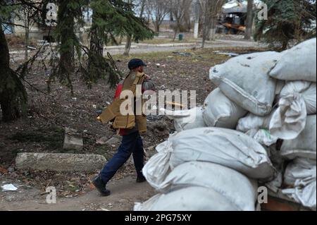 Avdiivka, Donetsk Oblast, Ucraina. 20th Mar, 2023. Un operaio della città di Avdiivka trasporta l'armatura del corpo mentre pulisce i detriti nella città. La città è stata sottoposta a un pesante incendio dall'inizio dell'invasione. (Credit Image: © Madeleine/ZUMA Press Wire) SOLO PER USO EDITORIALE! Non per USO commerciale! Foto Stock