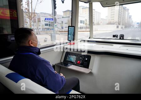 Xiong'an, provincia cinese di Hebei. 20th Mar, 2023. Un addetto alla sicurezza è raffigurato all'interno di un autobus intelligente collegato in un'operazione di prova su una strada nell'area di Rongdong nella Nuova area di Xiong'an, nella provincia di Hebei della Cina settentrionale, il 20 marzo 2023. Questo autobus per passeggeri a guida autonoma è dotato di sensori ad alta precisione, tra cui radar laser, radar ad onde millimetriche e telecamere HD, ed è in grado di prendere decisioni operative in un decimo di secondi. Può anche affrontare condizioni meteorologiche avverse e complicare le situazioni di traffico. Credit: MU Yu/Xinhua/Alamy Live News Foto Stock