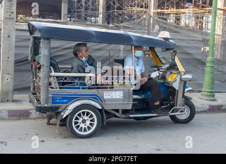 SAMUT PRAKAN, THAILANDIA, 28 2023 GENNAIO, gli uomini riposano in un triciclo tuk-tuk parcheggiato sulla strada Foto Stock