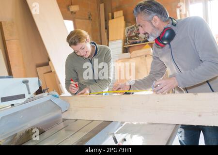 apprendimento del falegname durante la lezione di apprendistato di misurazione Foto Stock