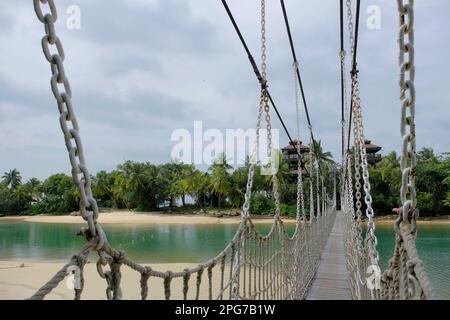 Ponte sospeso dalla spiaggia di Palawan sull'isola di Sentosa, Singapore, che porta al "punto più meridionale dell'Asia continentale" Foto Stock