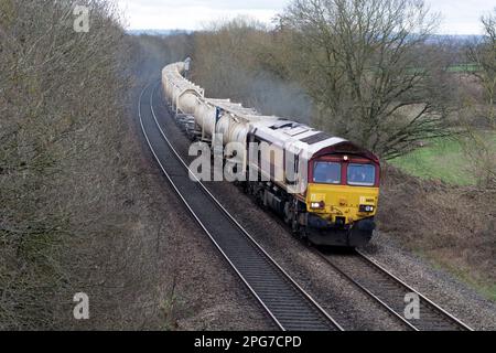 LOCOMOTIVA diesel CLASSE 66 DB che tira serbatoi interbulk presso Hatton Bank, Warwickshire, Regno Unito Foto Stock