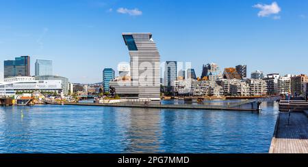 Oslo, Norvegia - 15 agosto 2022: Edificio di architettura moderna della città con lo skyline di Oslo nel quartiere di New Bjørvika con il panorama del museo Munch a Oslo, Norvegia. Foto Stock