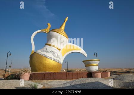 Una gigantesca scultura in cemento di un tè tradizionale, caffettiera e tazza nel mezzo di una rotonda stradale, rotante vicino a Zayed City. Vicino Abu Dhabi, Emirati Arabi Uniti Foto Stock