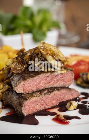 Fette di bistecca alla griglia con patatine fritte Foto Stock