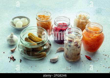 Cibo fermentato. Conserve vegetali. Crauti, cetrioli sottaceto, kimchi ecc. in vasetti di vetro, con pepe e aglio. Dieta probiotica sana Foto Stock