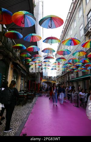 Lisbona, Portogallo - 21 ottobre 2022: Ombrelli multicolore appesi sulla strada rosa a Lisbona, Portogallo Foto Stock