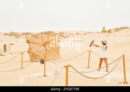 Donna vlogger contenuti turistici creatore visita esplorare le strutture di Fossil Dunes nel deserto. Abu Dhabi, Emirati Arabi Uniti. Famosa destinazione di viaggio Foto Stock