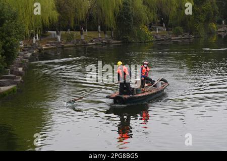 (230321) -- HANGZHOU, 21 marzo 2023 (Xinhua) -- lavoratori puliscono la superficie dell'acqua sul fiume Dongtai nel distretto di Beilun di Ningbo, provincia di Zhejiang della Cina orientale, 16 marzo 2023. La provincia di Zhejiang ha preso la gestione dell'ambiente idrico come priorità assoluta nella costruzione ecologica, elevando la qualità dell'acqua di centinaia di laghi e fiumi e stabilendo siti di attività civica sul lungomare. (Xinhua/Huang Zongzhi) Foto Stock