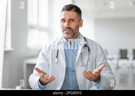 Concetto di terapia a distanza. Ritratto di medico maschio che parla online con il paziente, videochiamata, consulenza specialistica Foto Stock