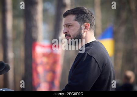 Moschun, Ucraina. 21st Mar, 2023. Il presidente ucraino Volodymyr Zelenskyy consegna le sue osservazioni durante una cerimonia presso il sito commemorativo degli Angeli della Vittoria, 21 marzo 2023 a Moschun, Kyiv Oblast, Ucraina. Credit: Foto piscina/Ufficio stampa presidenziale ucraino/Alamy Live News Foto Stock