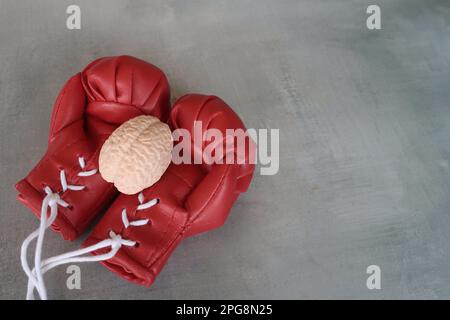 Modello di cervello umano sopra i guanti di boxe con spazio di copia. Concetto di lotta contro le malattie del cervello Foto Stock