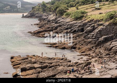 Veduta aerea, turisti che fanno il bagno tra le rocce sulla spiaggia sabbiosa di Cala Sonabia nel Mar Cantabrico, Golfo di Biscaglia, Cantabria, Spagna, Europa, Foto Stock