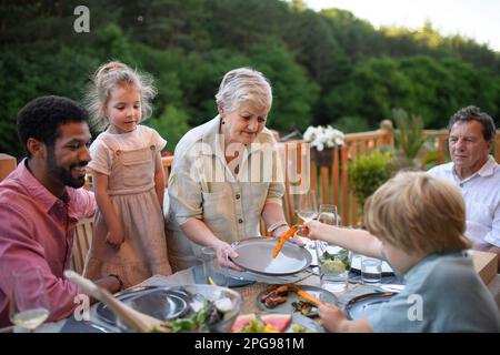 Famiglia multigenerazionale cena al barbecue party. Foto Stock