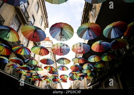 Lisbona, Portogallo - 21 ottobre 2022: Ombrelli multicolore appesi sulla strada rosa a Lisbona, Portogallo Foto Stock