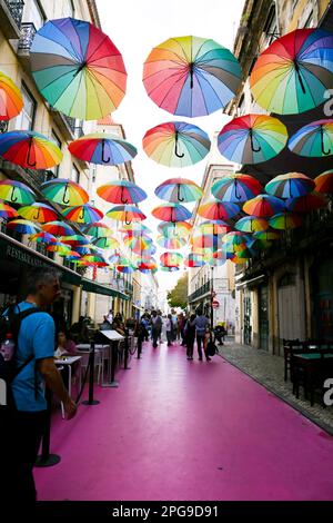 Lisbona, Portogallo - 21 ottobre 2022: Ombrelli multicolore appesi sulla strada rosa a Lisbona, Portogallo Foto Stock