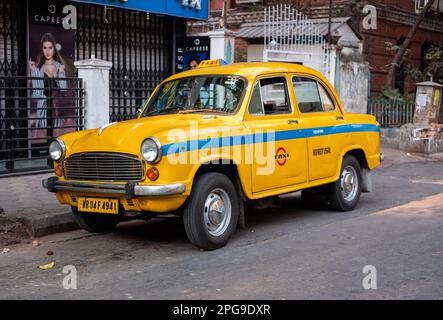 Un taxi giallo Ambassador parcheggiato in una strada a Kolkata, India. Foto Stock