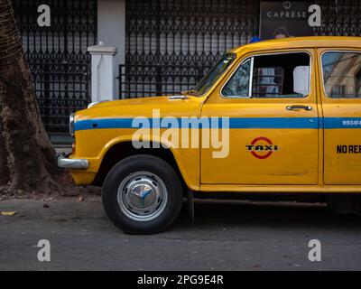 Un taxi giallo Ambassador parcheggiato in una strada a Kolkata, India. Foto Stock