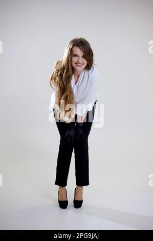 Mani dello chef. Igiene della cucina. Donna che indossa guanti in lattice nero isolato su sfondo chiaro copia spazio. Cucina professionale. Classe master. chef femminile in pantaloni neri e giacca bianca in studio bianco Foto Stock