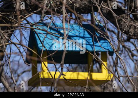 Una birdhouse dipinta nei colori della bandiera dell'Ucraina è appesa su un albero nei parchi di una città in Ucraina Foto Stock
