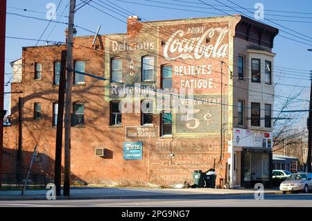 Schenectady, NY, USA: Grande, Coca-Cola dipinto a mano segno pubblicitario sul lato di tre piani, edificio in mattoni illuminato dal sole della sera. Visualizzazione completa b Foto Stock