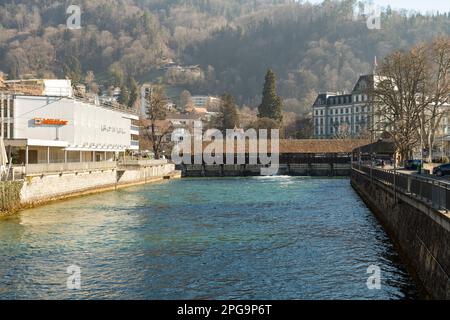 Thun, Svizzera, 13 febbraio 2023 storico ponte di legno vecchio attraverso il fiume Aare sul lungomare nel centro della città Foto Stock