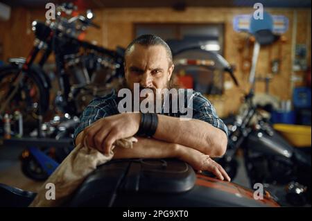 Ritratto dell'uomo biker maturo sopra il suo cavallo di metallo moto Foto Stock