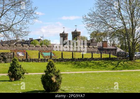 Primavera nella città di Antrim, Irlanda del Nord, con merlature del Barbican Gate Lodge viste dai Giardini del Castello di Antrim. Foto Stock