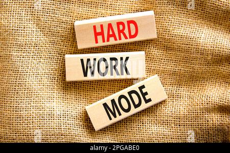 Simbolo della modalità lavoro duro. Concetto parole modalità di lavoro duro su blocco di legno su uno sfondo di tela bella tavola di tela. Concetto di modalità lavoro aziendale e lavoro duro Foto Stock