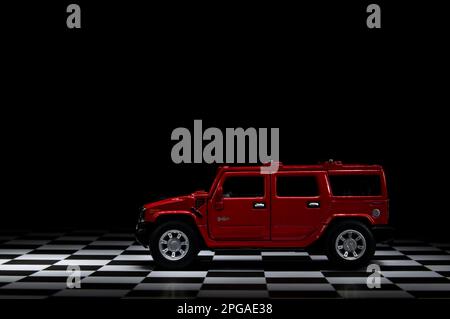 Smirne, Turchia - 15 marzo 2023. Veicolo fuoristrada Hummer H2 4x4 di colore rosso su un terreno a plaid e sfondo nero. Foto Stock