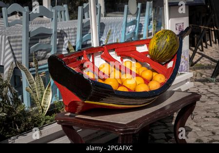 Arance e melone in mostra su un modello di barca da pesca portoghese Foto Stock