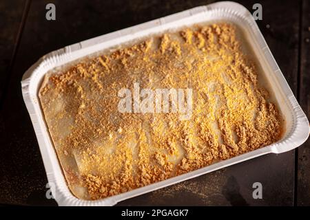 Lasagne congelate in forma di carta su sfondo scuro. Semilavorato. Foto Stock