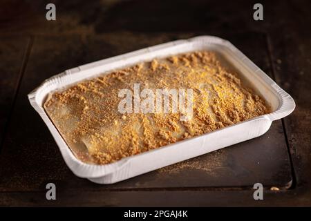 Lasagne congelate in forma di carta su sfondo scuro. Semilavorato. Foto Stock