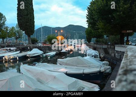 Piccole barche nel porto di Portese sul Lago di Garda, al tramonto Foto Stock