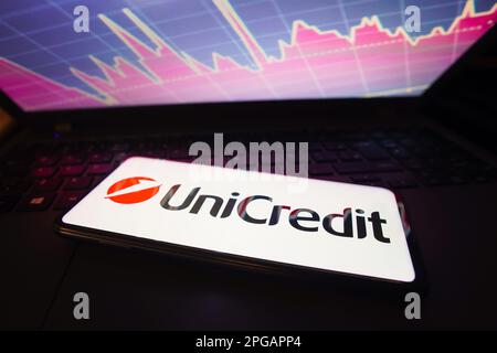 21 marzo 2023, Brasile. In questa foto l'UniCredit visto visualizzato sullo schermo di uno smartphone, con rappresentazione grafica del mercato azionario in background Credit: SOPA Images Limited/Alamy Live News Foto Stock