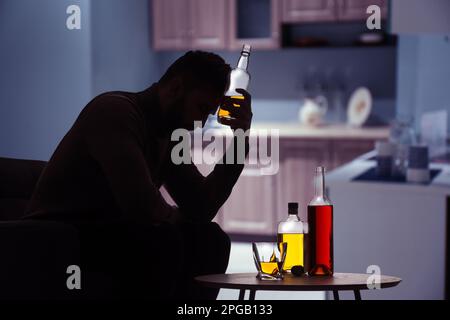 Silhouette di uomo addicted con bevande alcoliche in cucina Foto Stock