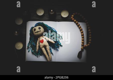 Composizione piatta con bambola voodoo su tavolo di legno scuro Foto Stock