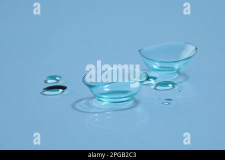 Lenti a contatto e gocce d'acqua su sfondo azzurro Foto Stock