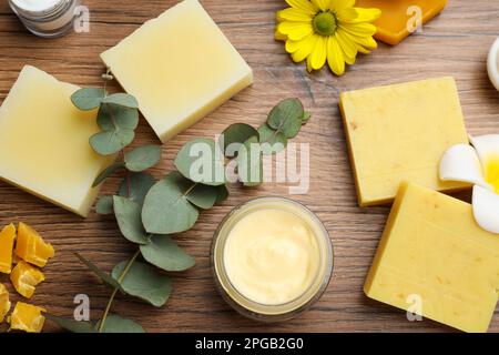 Composizione di posa piatta con cera d'api e prodotti cosmetici su tavola di legno Foto Stock