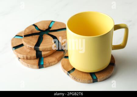 Tazza e eleganti montagne russe in legno su un tavolo in marmo bianco Foto Stock