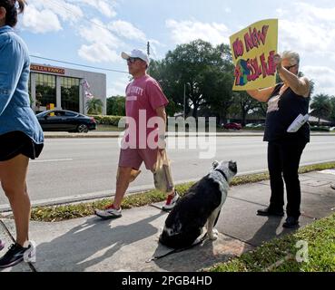 Hollywood, Florida, Stati Uniti. 21st Mar, 2023. JAMIE AMICO, di Hollywood, Florida e il suo cane Luna prendono parte a una protesta a livello nazionale rivolta alle grandi banche che hanno investito nel settore dei combustibili fossili organizzato dal gruppo attivista più anziano Third Act. Gli attivisti del terzo atto e un'organizzazione locale di disinvestimento sul cambiamento climatico chiamata Get My Money out si sono riuniti per dimostrare in un angolo di strada trafficato a Hollywood, Florida, il 21 marzo 2023. Il terzo atto ha affermato che stava organizzando più di 80 proteste in contemporanea. L'intersezione ha caratterizzato Wells Fargo e Bank of America dirama quelli Foto Stock