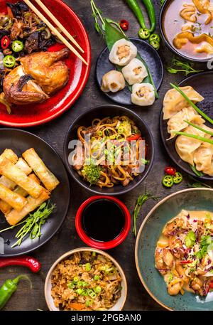 Un assortimento di piatti Cinesi. Tagliatelle cinesi, riso fritto, gnocchi, anatra alla pechinese, dim sum, involtini primavera. Famosa cucina Cinese piatti sulla tavola. Parte superiore Foto Stock