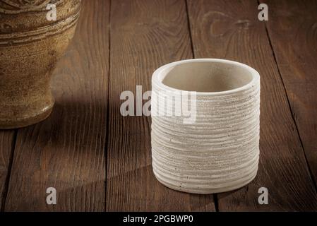 Caraffa in argilla per vino e bicchiere su fondo di legno scuro. Foto Stock