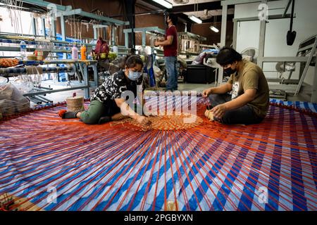 Bangkok, Thailandia. 22nd Mar, 2023. Gli operai tessono un tappeto grande da tessuto riutilizzato e spreco di filato. Credit: Matt Hunt/Neato/Alamy Live News Foto Stock