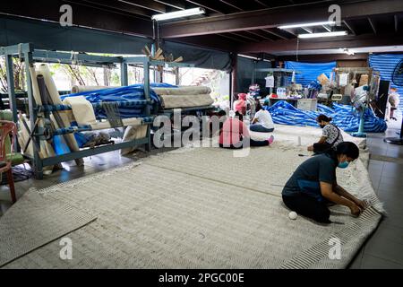 Bangkok, Thailandia. 22nd Mar, 2023. Gli operai tessono un tappeto grande da tessuto riutilizzato e spreco di filato. Credit: Matt Hunt/Neato/Alamy Live News Foto Stock