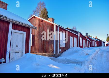 File con capanne rosse nella città della chiesa di Gammelstad situata vicino alla città svedese Lulea. Patrimonio dell'umanità dell'UNESCO. Foto Stock