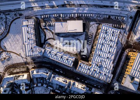 Panorama aereo top down complesso residenziale dopo una tempesta di neve con Ettegerpark visto dall'alto con tetto pieno di pannelli solari coperti di bianco Foto Stock