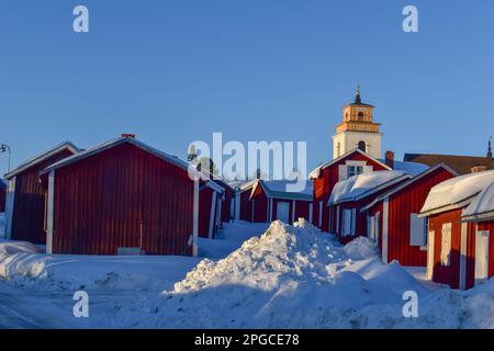 File con capanne rosse nella città della chiesa di Gammelstad situata vicino alla città svedese Lulea. Patrimonio dell'umanità dell'UNESCO. Foto Stock